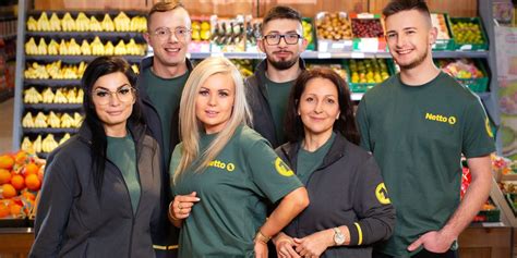 Pracownik Netto układający towar na półce