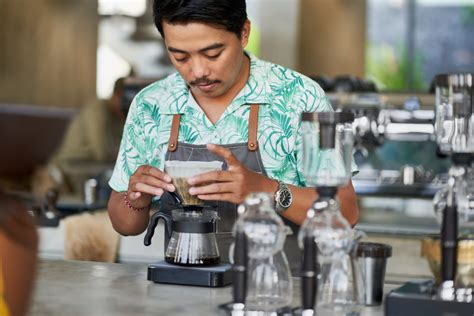 zdjęcie uśmiechniętego baristy Costa Coffee przygotowującego kawę
